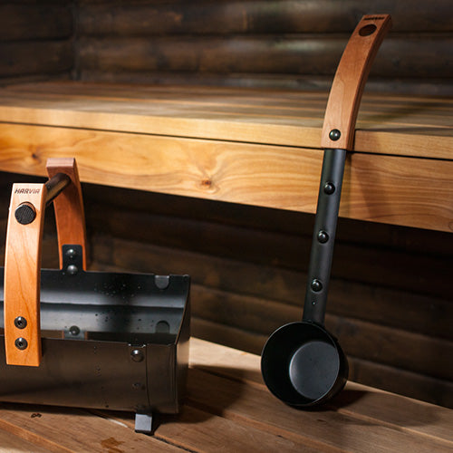 Harvia sauna ladle next to matching black bucket